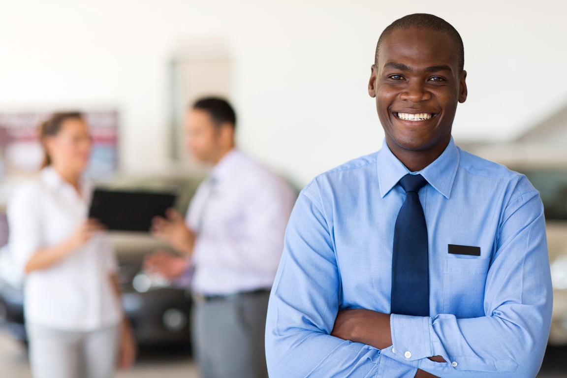 african car salesman looking at the camera